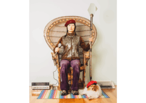a photograph of a person in a chair with a dog nearby