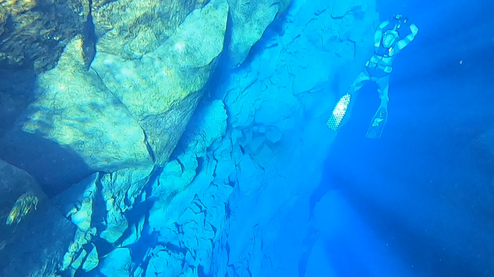 a film still showing an underwater scene and a person scuba diving
