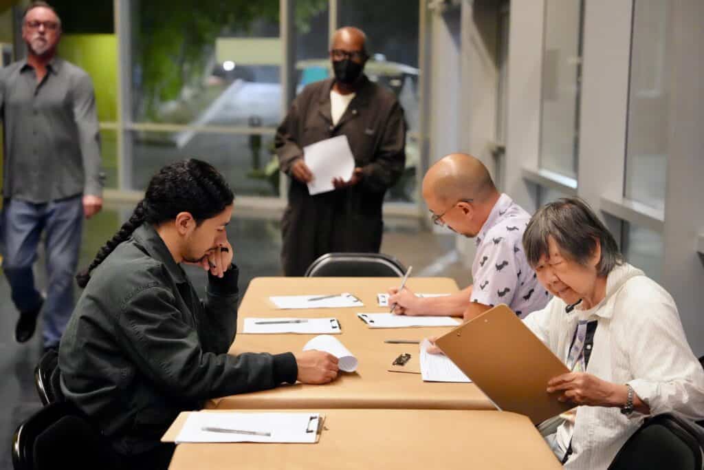 a few people at a table writing