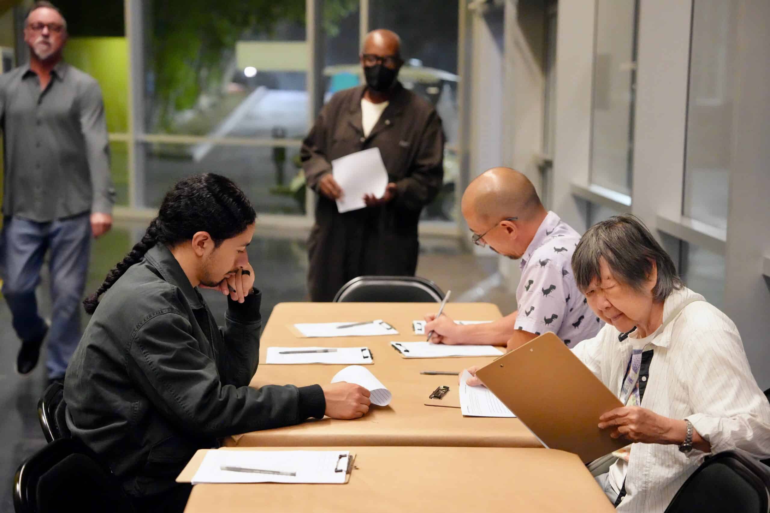 a few people at a table writing