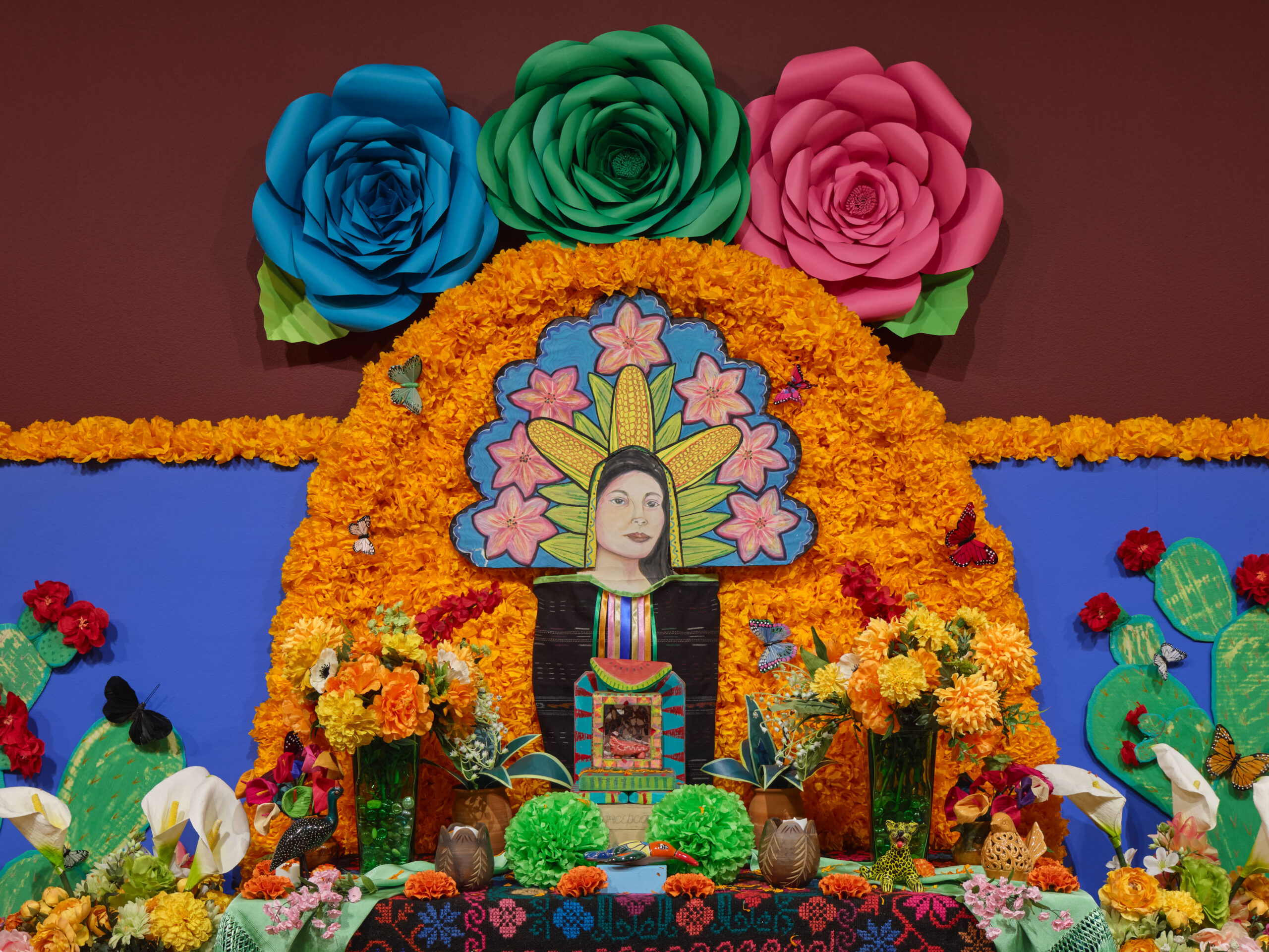 an altar with a woman's face and orange flowers